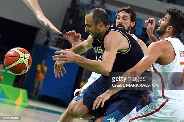 Argentina's shooting guard Manu Ginobili is sandwiched between Spain's guard Sergio Llull and Spain's point guard Ricky Rubio during a Men's round...