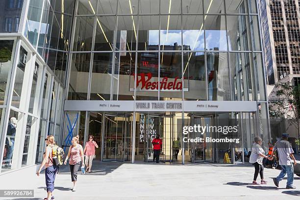 Workers and pedestrians walk past the entrance to the Westfield Corp. World Trade Center retail complex in New York, U.S., on Monday, Aug. 15, 2016....