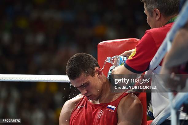 Russia's Evgeny Tishchenko is attended to as he fights Kazakhstan's Vassiliy Levit during the Men's Heavy Final Bout match at the Rio 2016 Olympic...