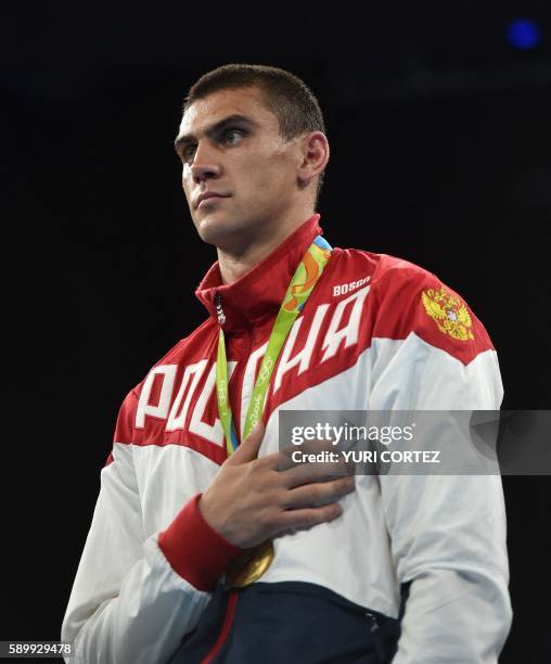 Russia's Evgeny Tishchenko poses on the podium with his medal after fighting against Kazakhstan's Vassiliy Levit during the Men's Heavy Final Bout...