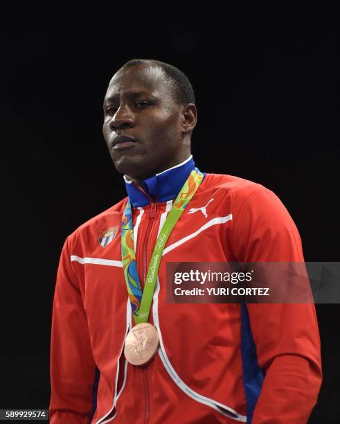 Cuba's Erislandy Savon poses on the podium with his medal after fighting against Kazakhstan's Vassiliy Levit during the Men's Heavy Final Bout match...