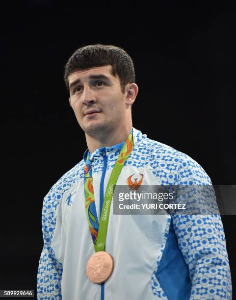 Uzbekistan's Rustam Tulaganov poses on the podium with the bronze medal following a boxing match at the Rio 2016 Olympic Games at the Riocentro -...