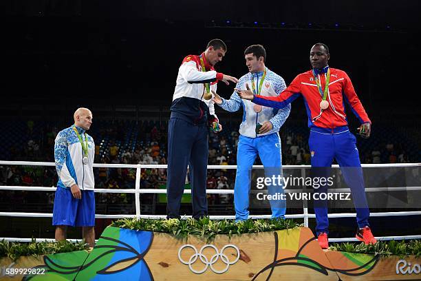 Kazakhstan's Vassiliy Levit, Russia's Evgeny Tishchenko, Uzbekistan's Rustam Tulaganov and Cuba's Erislandy Savon pose on the podium with their...