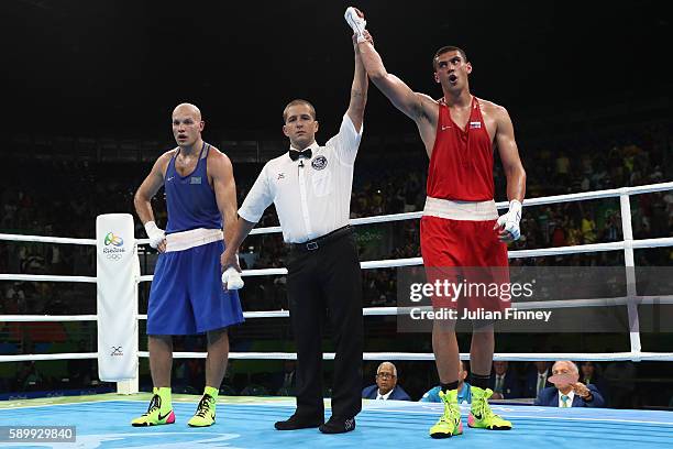 Evgeny Tishchenko of Russia celebrates winning the gold medal after the mens heavyweight 91kg next to Vassiliy Levit of Kazakhstan during the Boxing...