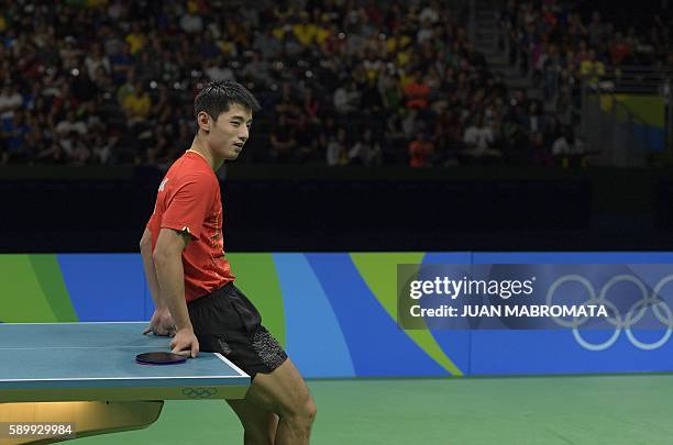 China's Zhang Jike leans on the table between points in the men's team semi-final table tennis match against South Korea at the Riocentro venue...