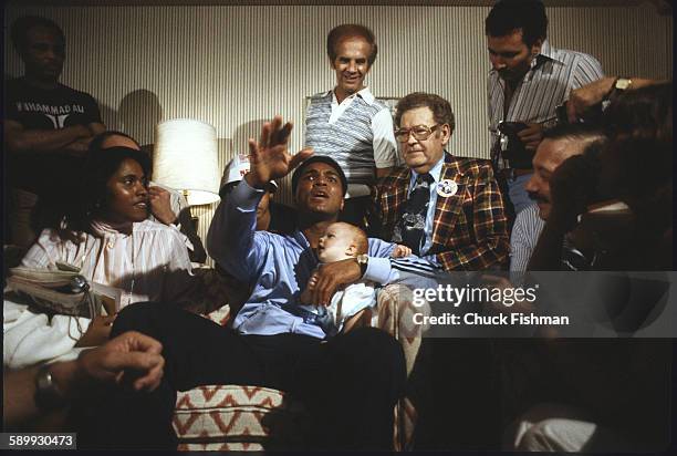 After his victory in a championship bout and surrounded by journalists and unidentified others, American heavyweight boxer Muhammad Ali holds his...