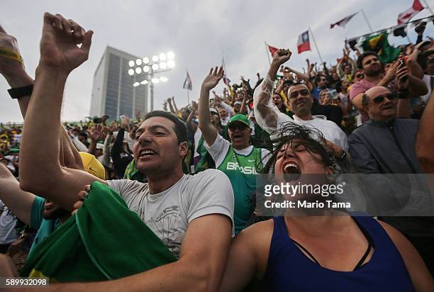 Brazilian fans cheer as their men's beach volleyball team defeats the United States during the Rio 2016 Olympic Games on August 15, 2016 in Rio de...