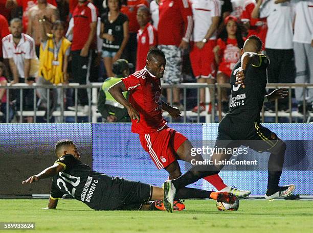 Jarol Martinez of America de Cali fights for the ball with Oaldier Morales and Jeison Quinonez of Bogota during a match between America de Cali and...