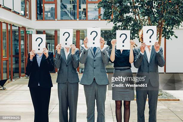 business people with question mark on placards - five people fotografías e imágenes de stock