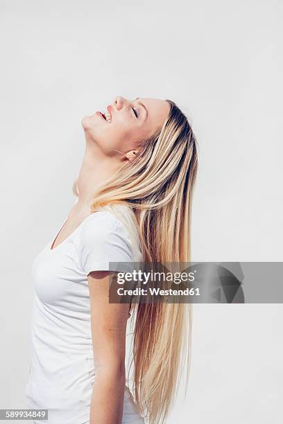 portrait of happy young woman with head back in front of white background - hair beauty imagens e fotografias de stock