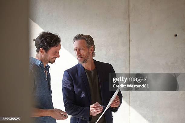 two men on construction site discussing document - architect stockfoto's en -beelden