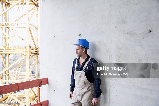 worker on construction site standing at concrete wall - laborer stock-fotos und bilder