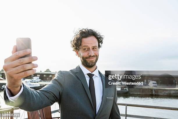germany, luebeck, businessman at harbor taking a selfie - arrogance stock pictures, royalty-free photos & images