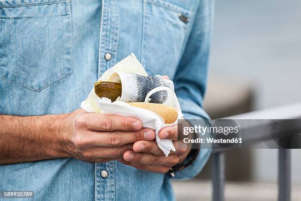 man holding a fish sandwich - bun fotografías e imágenes de stock