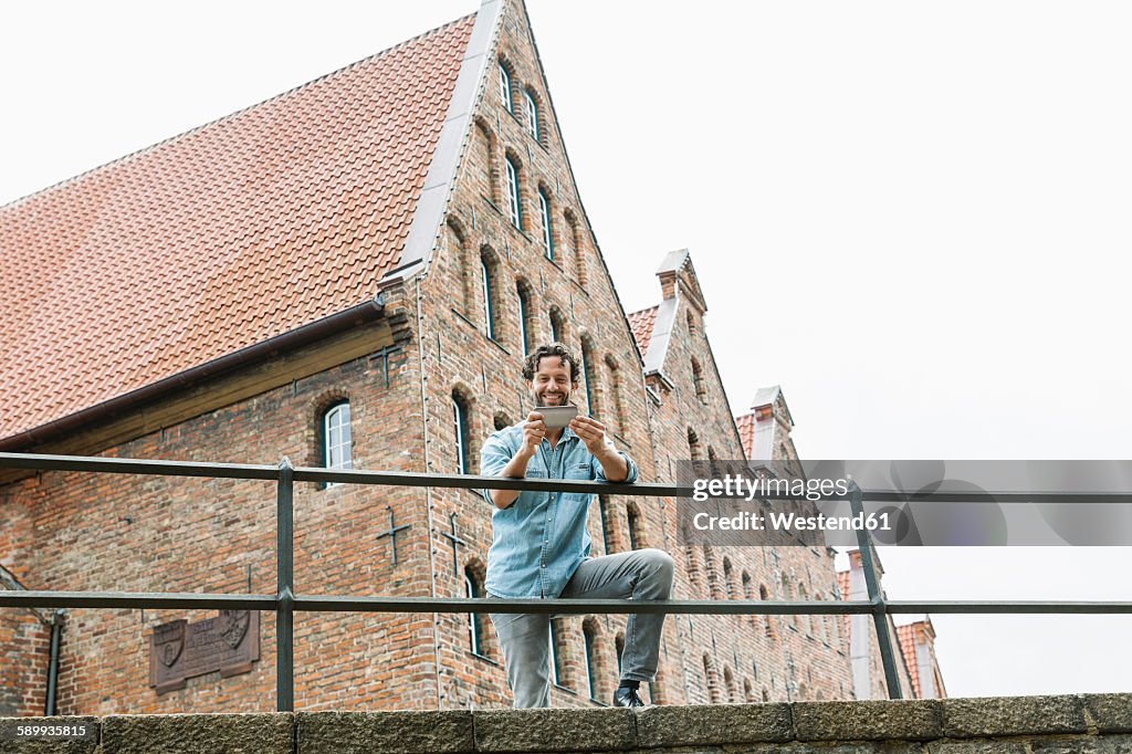 Germany, Luebeck, man with smartphone in the city