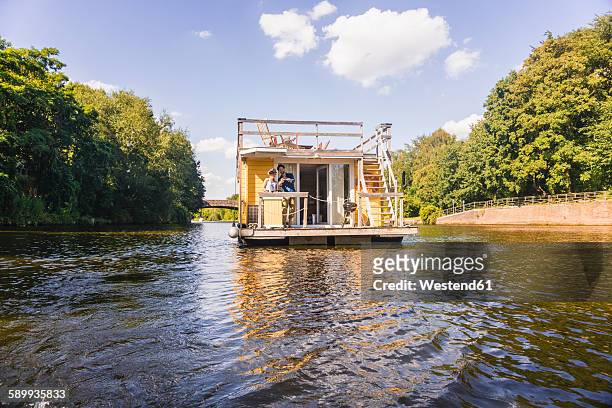 couple having a trip on a house boat - hausboot stock-fotos und bilder