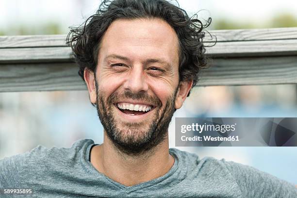 portrait of happy man outdoors - brown hair stock-fotos und bilder