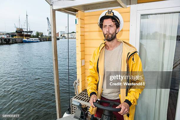 captain with cigar steering hpuse boat - team captain stock pictures, royalty-free photos & images
