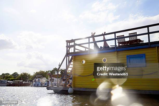 legs of a couple on roof terrace on a house boat - hausboot stock-fotos und bilder