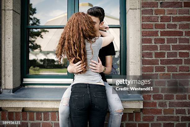 kissing teenage couple - young love stock-fotos und bilder