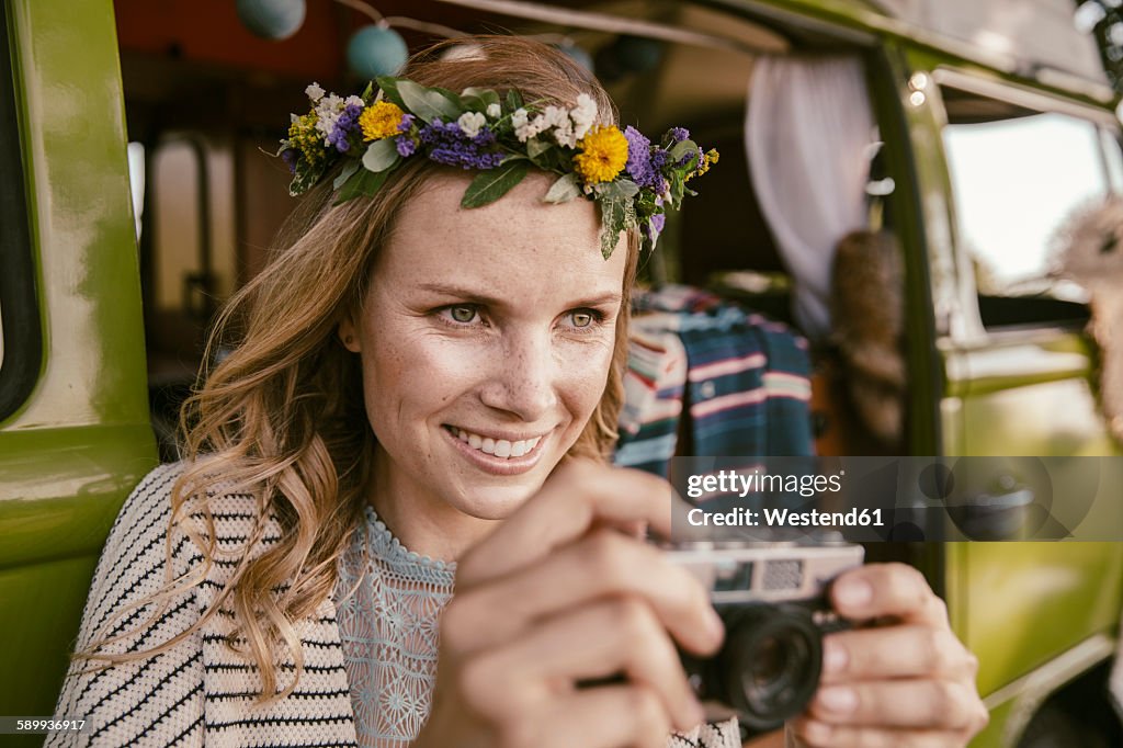 Hippie woman with analog camera in front of van