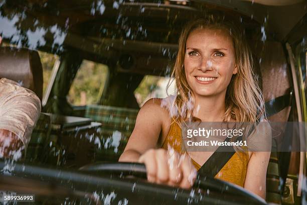 smiling woman driving van - young blonde woman facing away stock-fotos und bilder