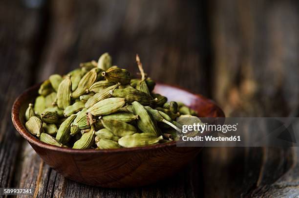 wooden bowl with cardamom capsules - cardamom stock pictures, royalty-free photos & images