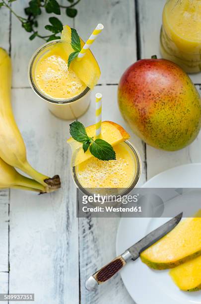 two glasses of mango banana smoothie - mango smoothie stock pictures, royalty-free photos & images