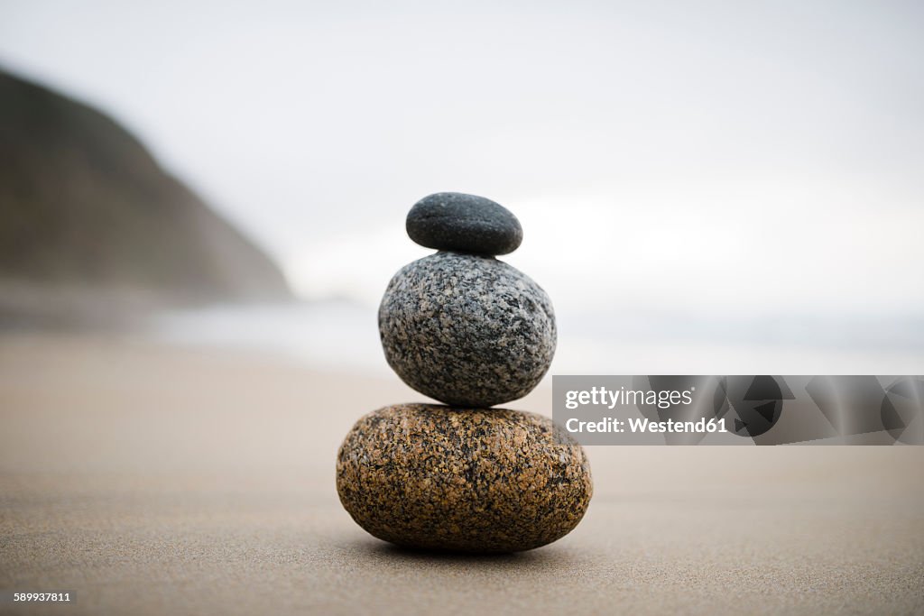Spain, three rocks balanced on the beach