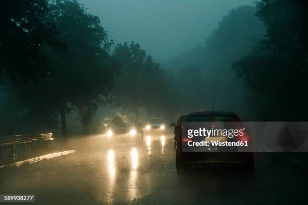 traffic on county road at rainstorm by twilight - tail light stock pictures, royalty-free photos & images