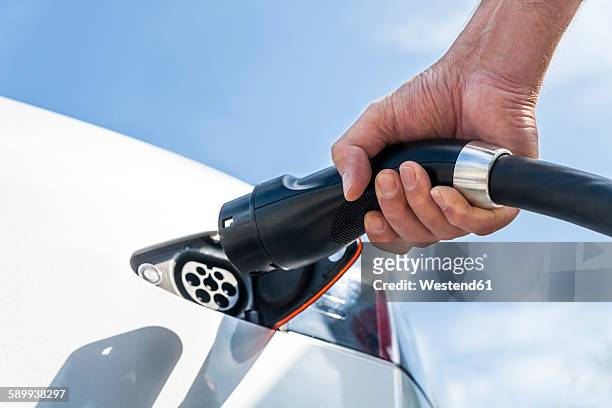 charging of an electric car - opladen stockfoto's en -beelden