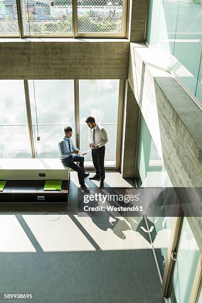 two young businessmen discussing documents - businessman distance window ストックフォトと画像