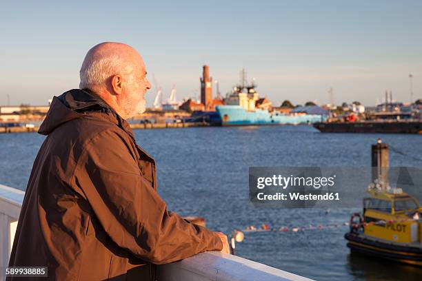 germany, lower saxony, cuxhaven, senior at harbor looking at view - cuxhaven stockfoto's en -beelden