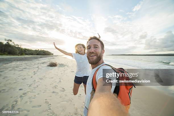 self portrait of playful young couple on beach at sunset - young couple on beach stock pictures, royalty-free photos & images