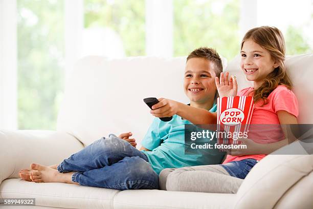 brother and sister watching television - boy watching tv stock pictures, royalty-free photos & images