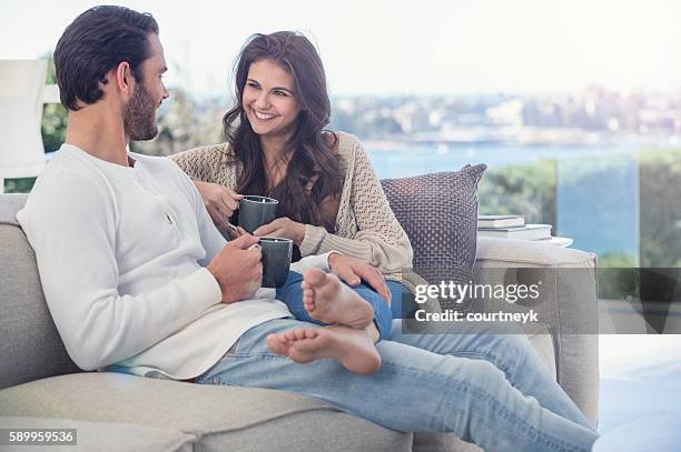 couple drinking coffee on he sofa. - feet up stock pictures, royalty-free photos & images