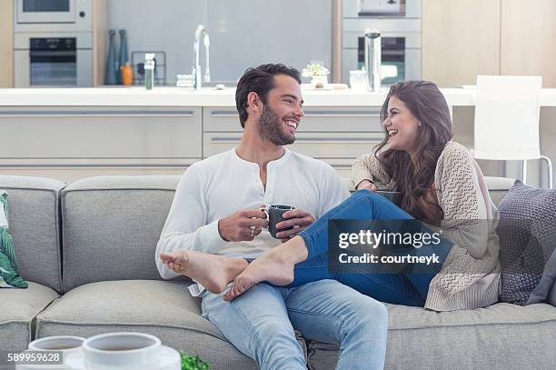 couple drinking coffee on the sofa. - feet up stock pictures, royalty-free photos & images
