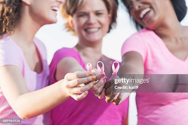 multirracial mãos segurando a fita de consciencialização contra o cancro - sensibilização-para-o-cancro-da-mama imagens e fotografias de stock