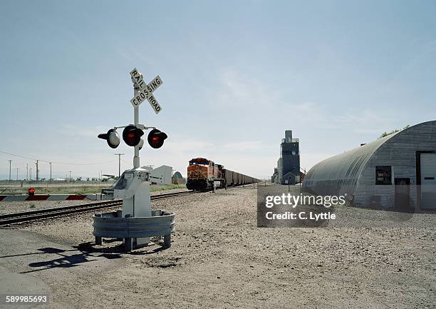 train nearing railroad crossing - quonset hut stock pictures, royalty-free photos & images