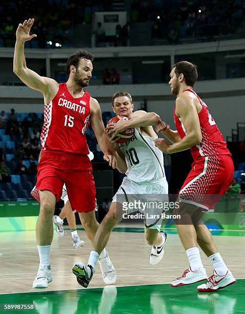 Renaldas Seibutis of Lithuania is challenged by Miro Bilan of Croatia and Bojan Bogdanovic of Croatia during a Men's Basketball Preliminary Round...