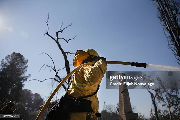 Firefighters work to put out lingering hot spots left by the Clayton Fire on August 15, 2016 in and around Lower Lake, California. Gov. Jerry Brown...