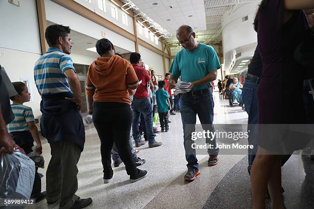 Eli Fernandez , from the Catholic Sacred Heart Immigrant Respite Center hands out tickets to Central American immigrants before their onward bus trip...