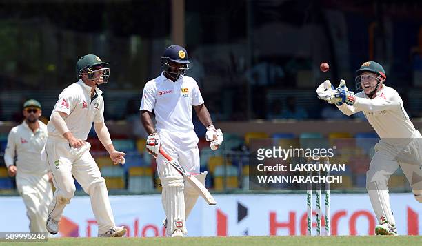 Sri Lanka's Kusal Perera watches as Australia's wicketkeeper Peter Nevill takes a catch to dismiss him during the fourth day of the third and final...