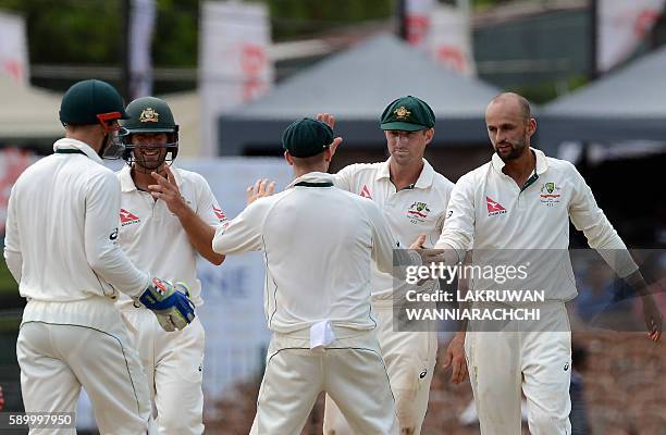 Australia's Nathan Lyon celebrates with teammates after he dismissed unseen Sri Lankan captain Angelo Mathews during the fourth day of the third and...