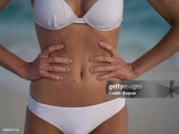 asia, maldives, close up of young caucasian woman's tummy on a tropical beach alone - flat stomach fotografías e imágenes de stock