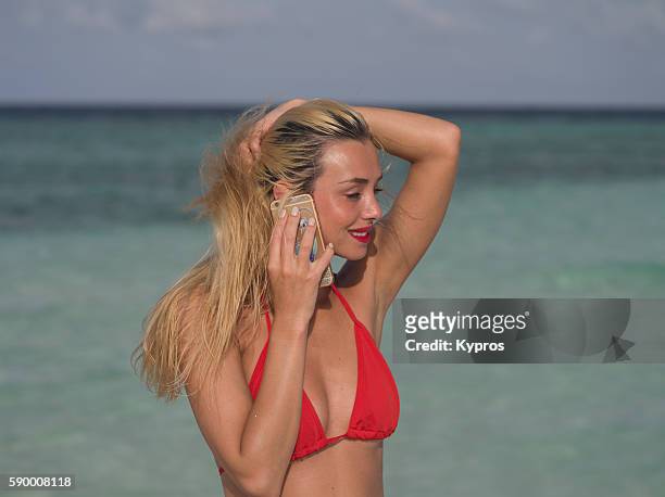 asia, maldives, young caucasian woman making phone call with smartphone on tropical beach "n - frau close up portrait stockfoto's en -beelden
