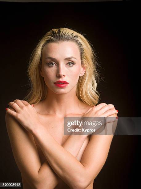 young caucasian woman covering her chest with her arms, close up, studio shot - risque woman stock pictures, royalty-free photos & images