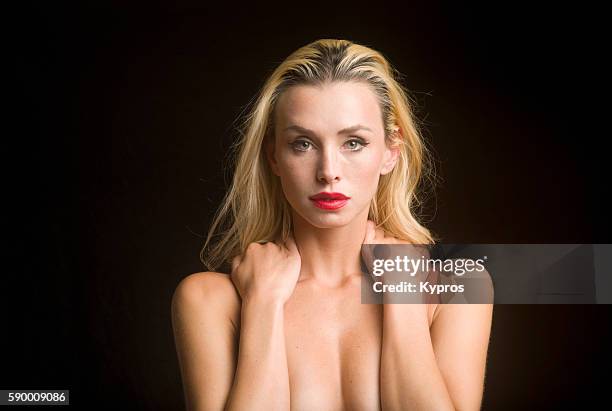 young caucasian woman covering her chest with her arms, close up, studio shot - risque woman foto e immagini stock