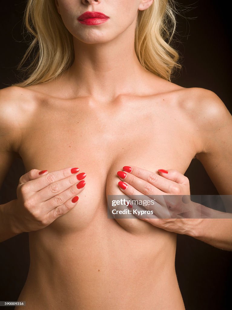 Studio Shot Of Young Woman's Hand Touching Her Breast During Self-Examination