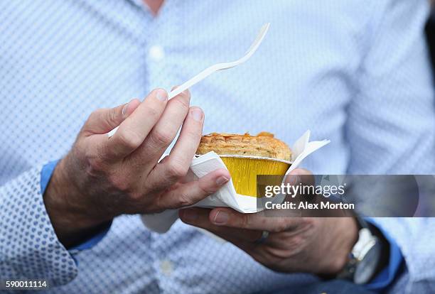 Fan eats a pie during the Premier League match between Hull City and Leicester City at KC Stadium on August 13, 2016 in Hull, England.